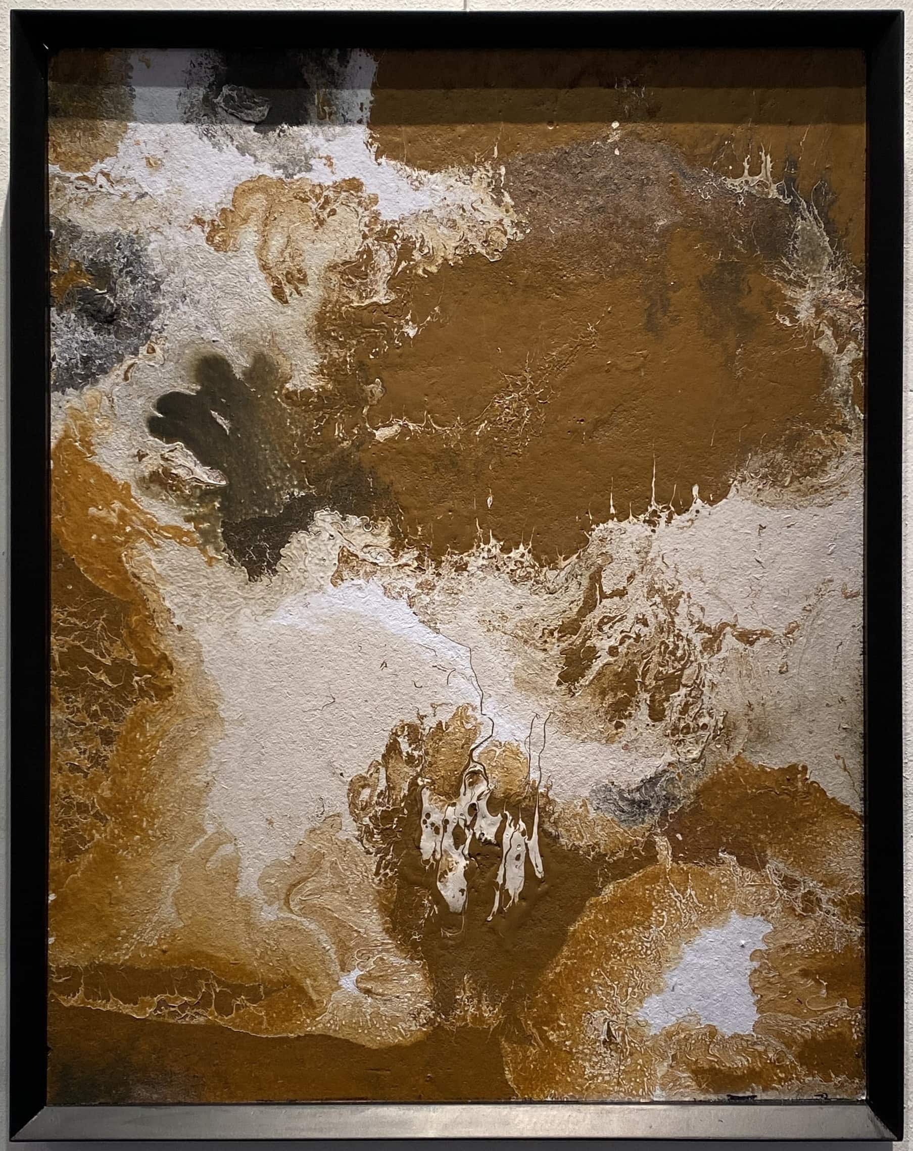 Een schilderij in oker en wit waarin de verf als water is uitgelopen, in een donkere lijst.